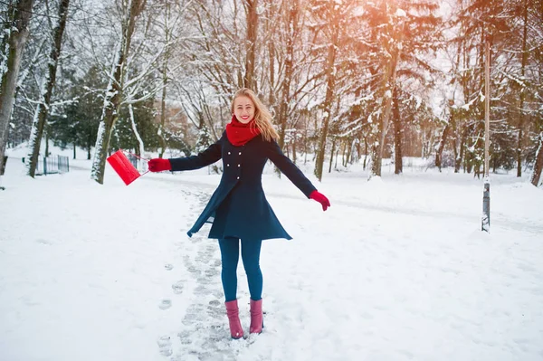 Blondynka w czerwonym szalikiem i płaszcz spaceru w parku na zimowe wieczory. — Zdjęcie stockowe