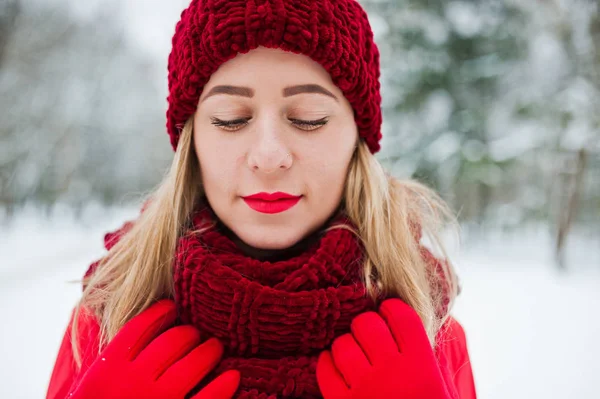 Blondes Mädchen in rotem Schal, Hut und Weihnachtsmann-Pullover posiert im Park — Stockfoto