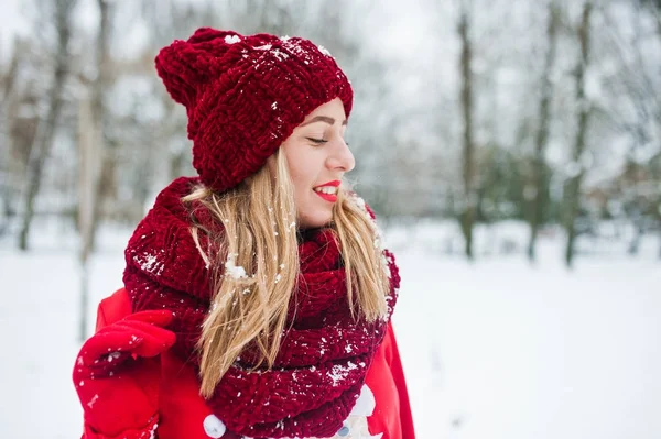 Blondes Mädchen in rotem Schal, Hut und Weihnachtsmann-Pullover posiert im Park — Stockfoto