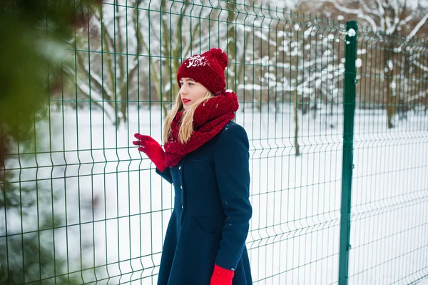 Menina loira em cachecol vermelho e casaco andando no parque no dia de inverno . — Fotografia de Stock