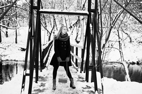 Blond meisje in de rode sjaal en jas lopen op brug in het park op w — Stockfoto