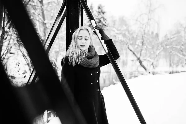 Blond meisje in de rode sjaal en jas lopen op brug in het park op w — Stockfoto