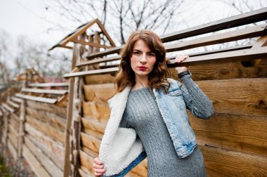 Ahşap w karşı kot ceketli esmer kıvırcık kız portresi