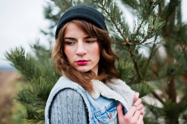 Noel t şapka ve kot ceketli esmer kız portresi