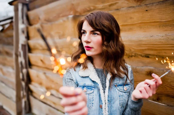 Porträtt av brunett tjej i jeansjacka med bengal lampor i — Stockfoto