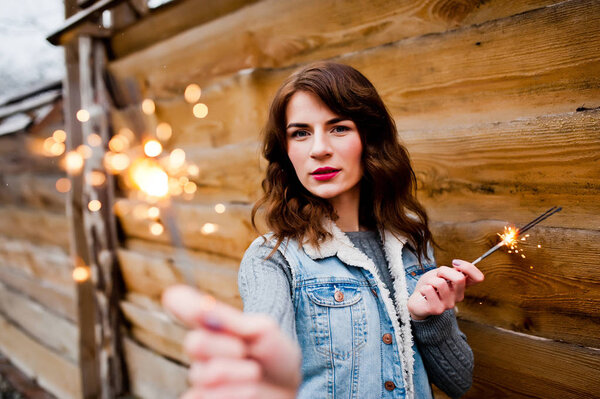 Portrait of brunette girl in jeans jacket with bengal lights in 