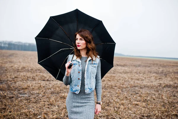 Portrait de fille brune bouclée en jean veste avec umbre noir — Photo