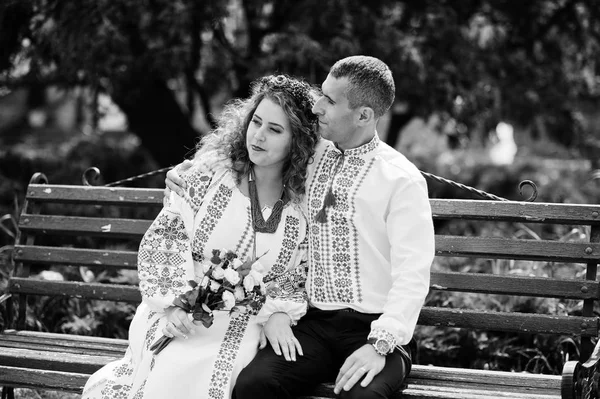 Cute wedding couple in ukrainian traditional clothes sitting on — Stock Photo, Image