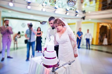 Evlilik çift restauran içinde onların büyük beyaz pasta kesme