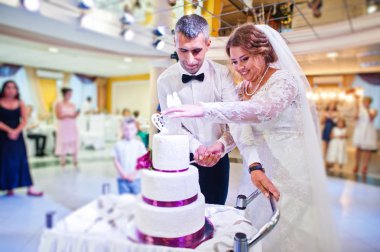 Evlilik çift restauran içinde onların büyük beyaz pasta kesme