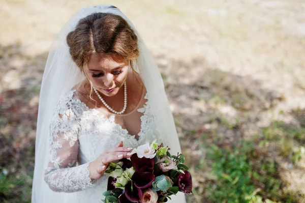 公園で彼女自身に彼女の白いドレスでポーズをとって孤独な花嫁. — ストック写真