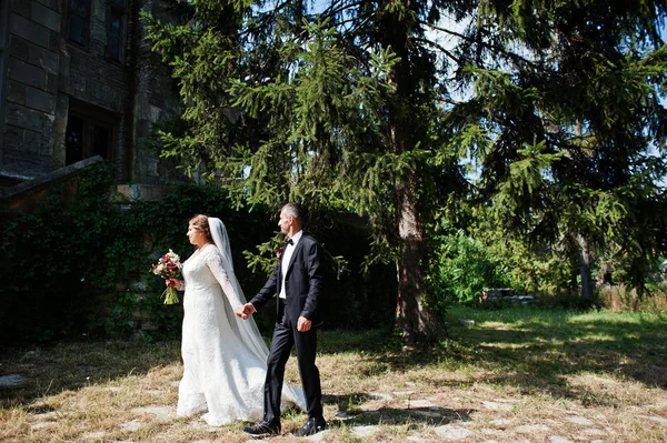 Casamento casal andando ao redor do castelo em seu dia do casamento . — Fotografia de Stock