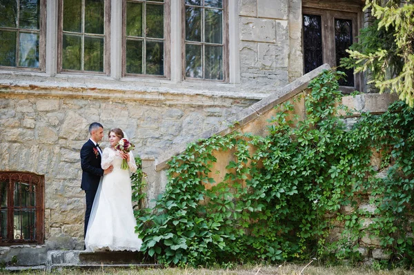 Romantic lovely newly married couple posing by the medieval cast — Stock Photo, Image