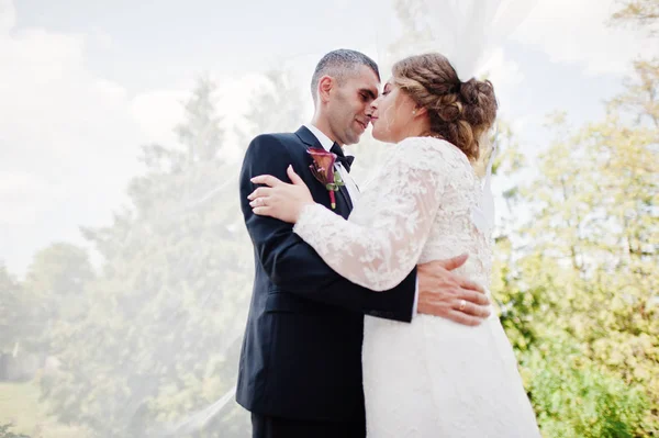 Romantic lovely newly married couple posing in the park by the m — Stock Photo, Image