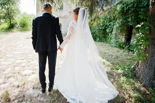 Matrimonio coppia a piedi intorno al castello il giorno del loro matrimonio . — Foto Stock