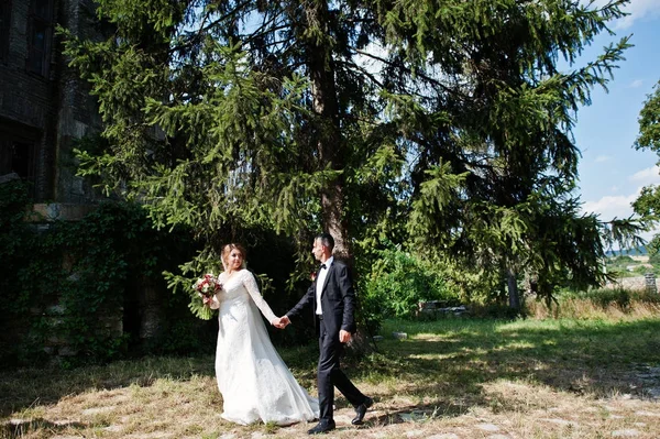 Wandelen rond het kasteel op hun huwelijksdag bruidspaar. — Stockfoto