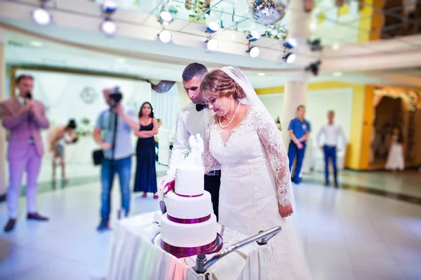 Evlilik çift restauran içinde onların büyük beyaz pasta kesme