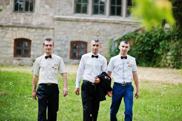 Γαμπρός ποζάρει με δύο groomsmen σε μια ημέρα ηλιόλουστη γάμο δίπλα στο τ — Φωτογραφία Αρχείου