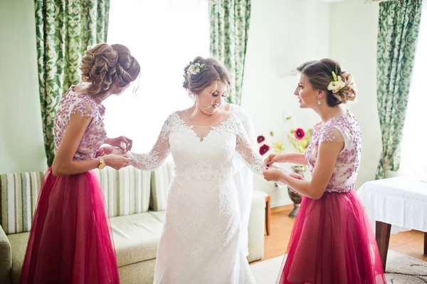 Härlig brudtärnor knutar på brudens manschetter innan hennes bröllop — Stockfoto