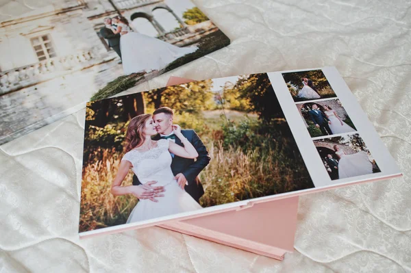 Seiten mit Hochzeitsfotos eines Fotobuchs oder Fotoalbums auf dem Bett. — Stockfoto