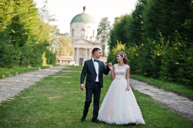 Güzel düğün çift uzanan yeşil sokak yürüyüş 