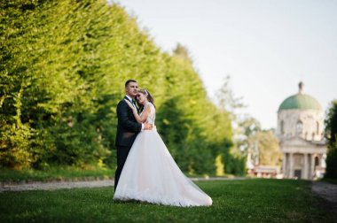 Güzel düğün çift uzanan yeşil sokak yürüyüş 