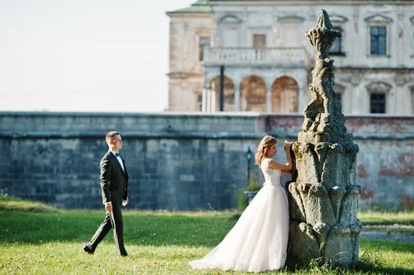 Cute newly married couple posing next to an old fountain on thei — Stock Photo, Image