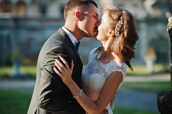 Carino coppia appena sposata baciare accanto a una vecchia fontana sul — Foto Stock