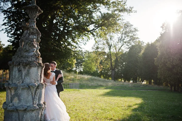 Mignon couple nouvellement marié embrasser à côté d'une vieille fontaine sur la — Photo