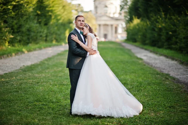 Lovely wedding couple walking along the green alley which leads — Stock Photo, Image