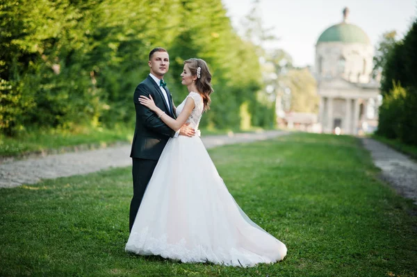 Charmant couple de mariage marchant le long de la ruelle verte qui mène — Photo