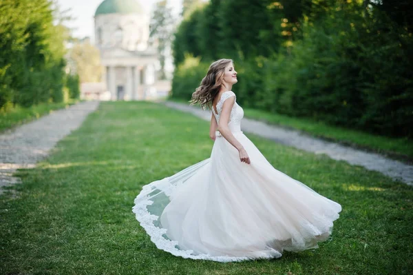 Sposa attraente solitario che cammina sul vicolo verde che porta t — Foto Stock