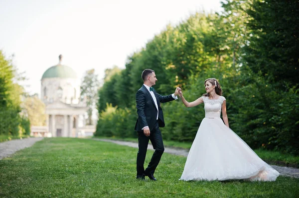 Hermosa pareja de boda caminando por el callejón verde que conduce — Foto de Stock