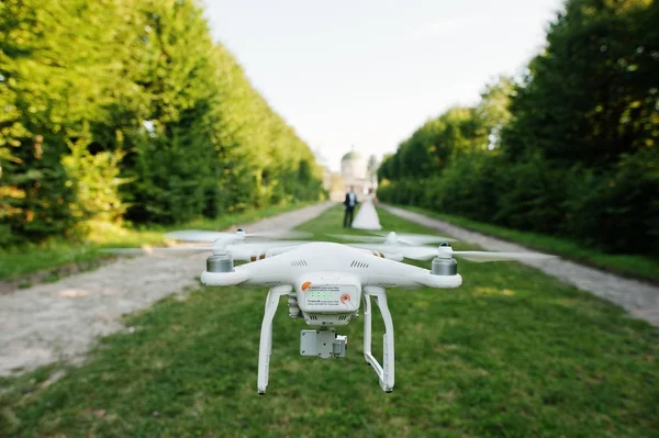 Photo en gros plan d'un drone filmant un couple de mariage pendant qu'ils marchent — Photo