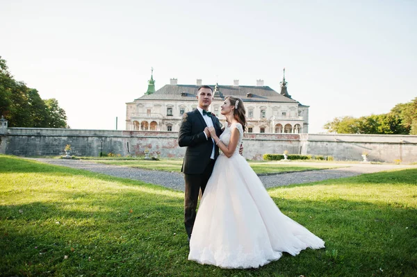 Fabulous wedding couple posing in front of an old medieval castl — Stock Photo, Image