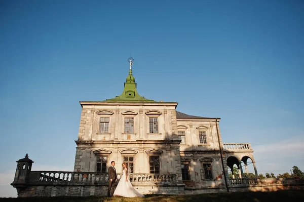 Fabelhaftes Hochzeitspaar posiert vor einem alten mittelalterlichen Schloss — Stockfoto