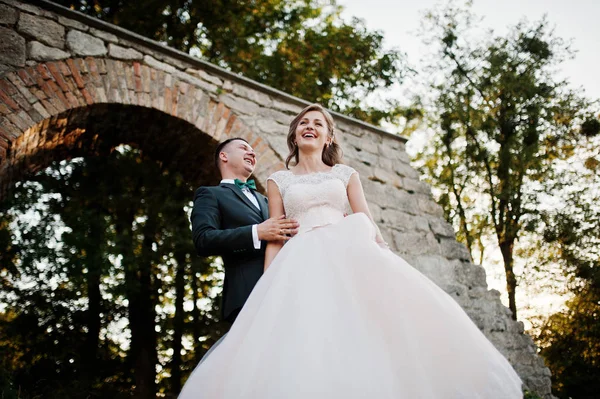 Bruid en bruidegom glimlachend en hebben geweldige tijd in het bos naast — Stockfoto