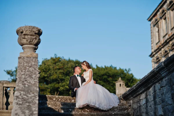 Romantisches Hochzeitspaar auf der Treppe neben dem Schloss — Stockfoto