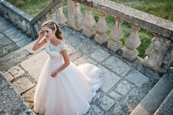 Retrato de una atractiva novia de pie junto al castillo en su —  Fotos de Stock