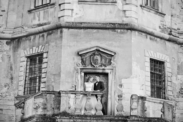 美しい結婚式のカップルがメインの城の扉の横にポーズします。B — ストック写真