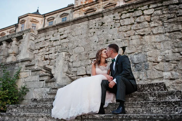 Couple de mariage romantique assis dans les escaliers à côté du château — Photo