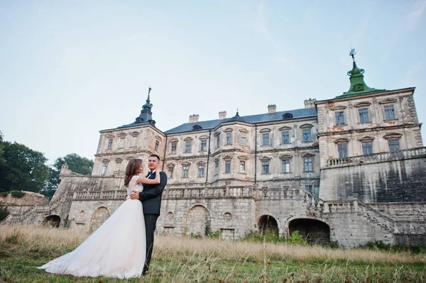 Fabulosa pareja de novios posando frente a un antiguo castillo medieval —  Fotos de Stock