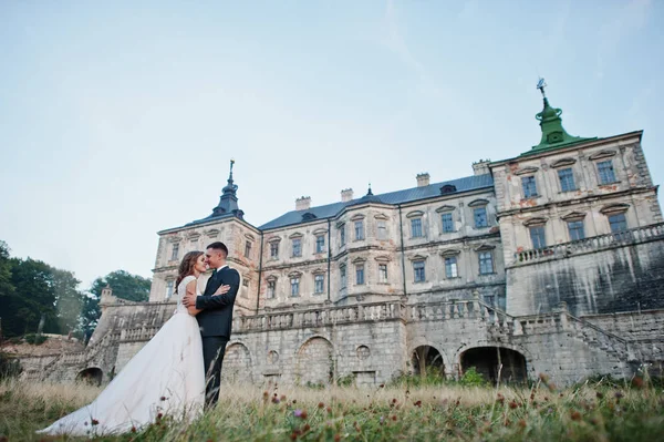 Fabelhaftes Hochzeitspaar posiert vor einem alten mittelalterlichen Schloss — Stockfoto