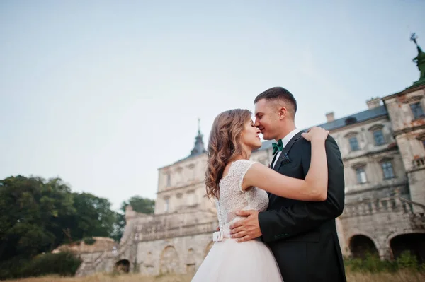 Utmärkt bröllop par poserar framför en gammal medeltida slott — Stockfoto