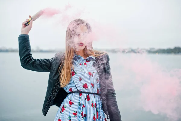 Snygg tjej i skinnjacka håller rosa rök utflytning på vintern d — Stockfoto