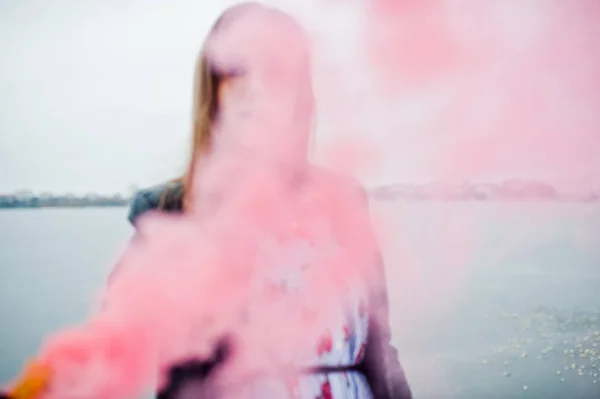 Stylowa dziewczyna w skórzanej kurtce przytrzymaj różowy dym flary w zimie d — Zdjęcie stockowe