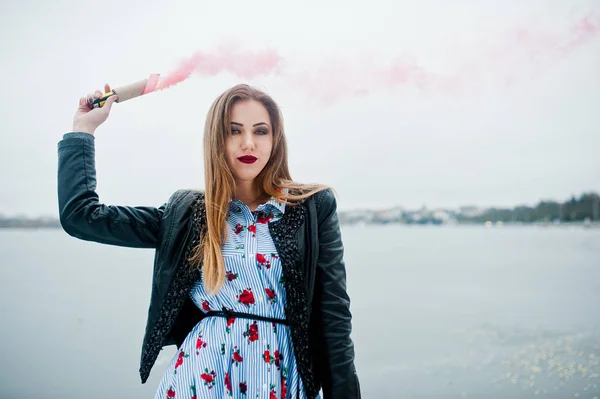 Menina elegante em jaqueta de couro segurar fogo de fumaça rosa no inverno d — Fotografia de Stock