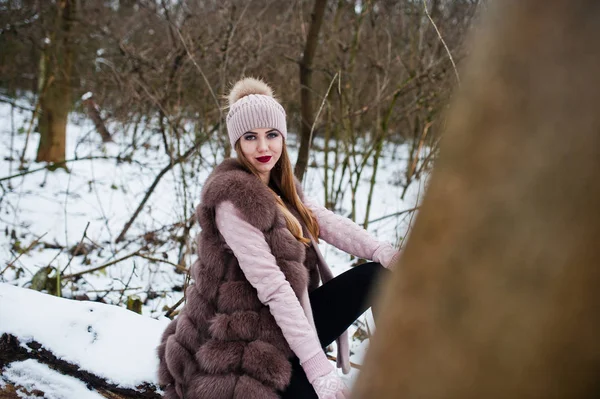 Stylisches Mädchen in Pelzmantel und Kopfbedeckung im Winterwald. — Stockfoto