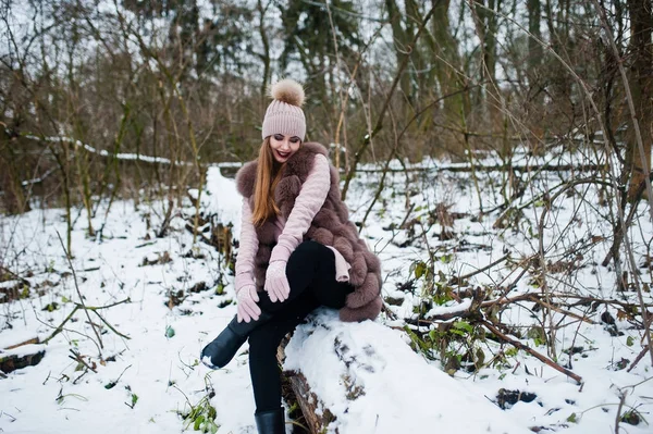 Menina elegante em casaco de pele e headwear na floresta de inverno . — Fotografia de Stock