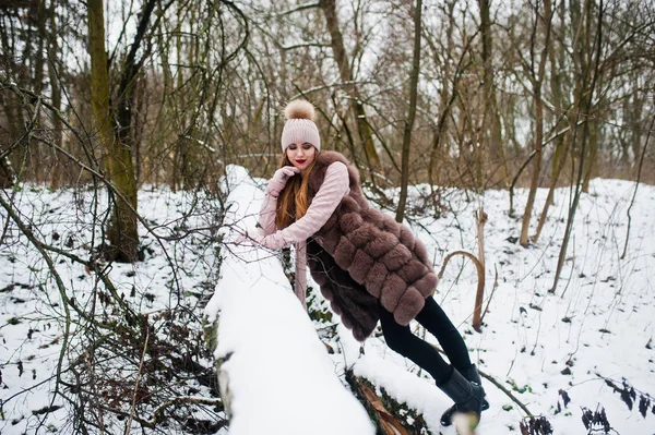 Menina elegante em casaco de pele e headwear na floresta de inverno . — Fotografia de Stock